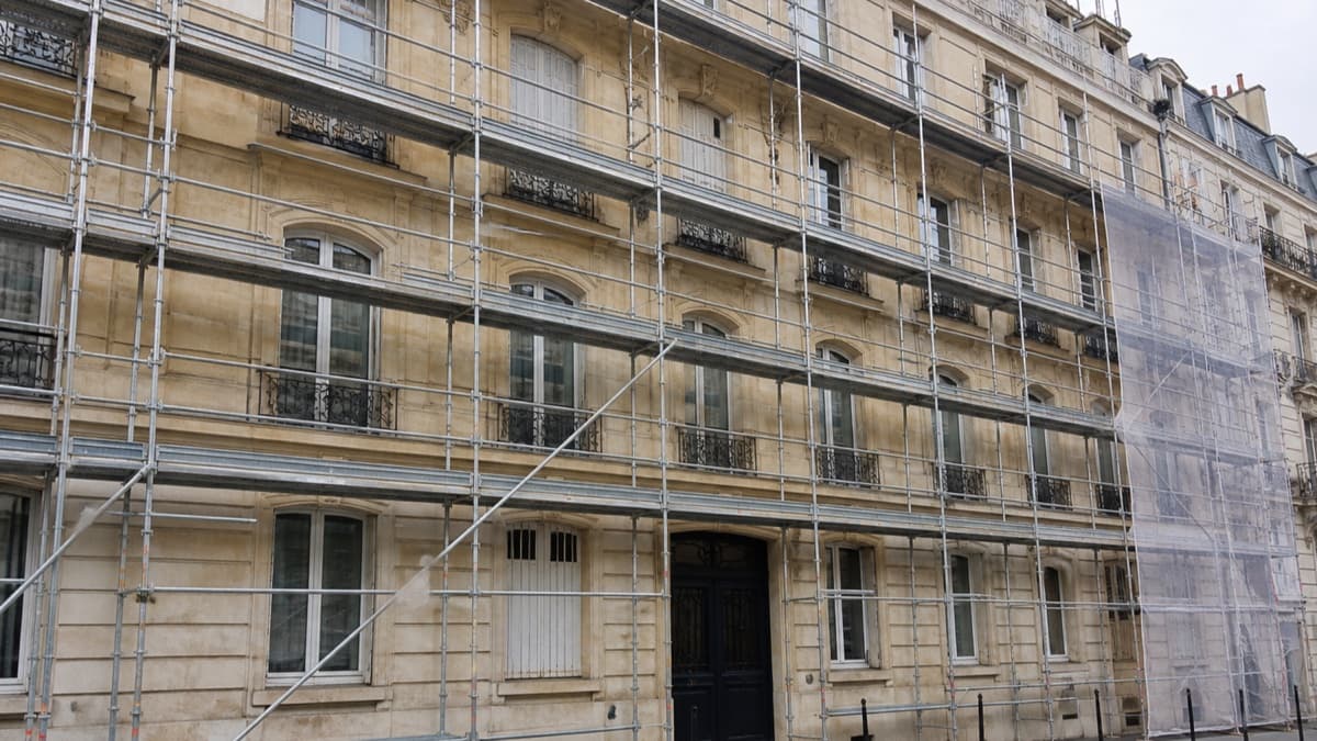 Façade d’un immeuble avec échafaudage et zones de finition visibles pendant un ravalement